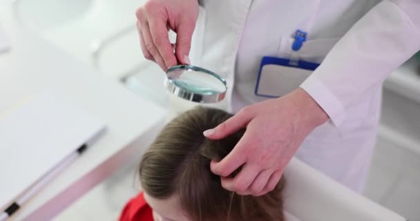 医生在医院用放大镜检查女病人的头发 专业工作人员检查学生头上的头发是否有女学生慢动作的头皮屑 — 图库视频影像