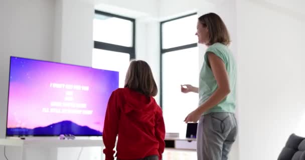 Μητέρα Και Κόρη Χορεύουν Καραόκε Στην Τηλεόραση Στο Σαλόνι Γονείς — Αρχείο Βίντεο