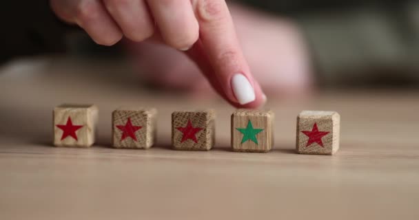 女性的手指向前移动木制立方体与绿星从一排桌子上 强调重要和正确事物的概念慢动作 — 图库视频影像