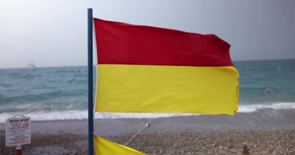 Κόκκινη Και Κίτρινη Σημαία Διάσωσης Κυματίζει Στην Έντονη Θαλασσινή Αύρα — Αρχείο Βίντεο