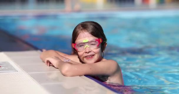 穿着护目镜 在宾馆游泳池里微笑的少女在游泳 快乐的小女生喜欢在异国情调的度假胜地度过家庭假期 — 图库视频影像