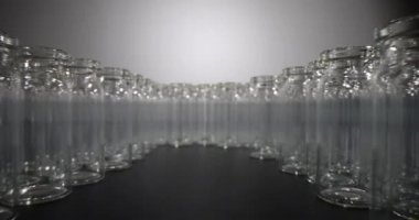 Empty glass vials for vaccines stand in circle in semi-lit premise. Transparent bottles intended for storage of medications and medical purposes on black table