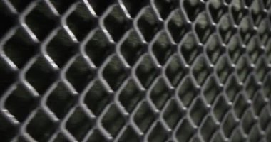 Grey perforated metal mesh as fence of private territory and housing. Concept of square grid pattern and texture as seamless design element