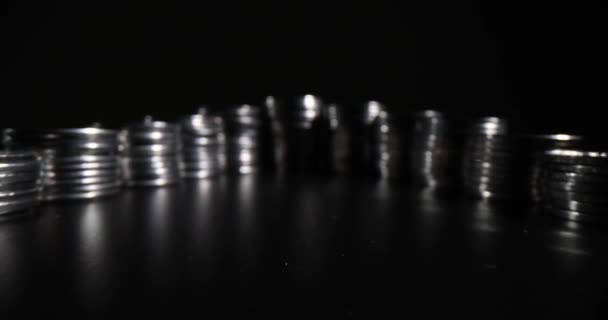 Curly Lines Stacks Made Silver Coins Standing Black Table Dark – stockvideo