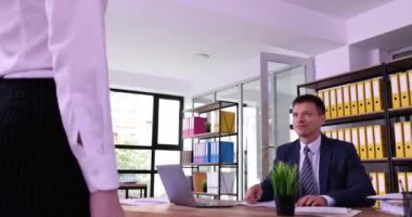 Businesswoman comes to boss table for handshake greeting in office. Manager greets colleague at corporate meeting. Communication in company