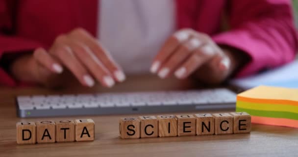在木制立方体上与妇女在桌旁键盘上打字相对照的数据科学 女士分析员处理坐在办公室办公桌前的数字数据集 — 图库视频影像