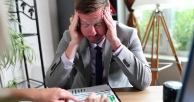 Ofisteki yorgun adam başını tutar, yakın plan. Kavram, mali beyanlarda hata, yanlışlık