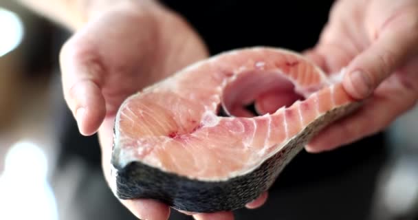 手は新鮮な光沢のあるステーキ クローズアップを保持します 健康食品 魚屋の一部 — ストック動画