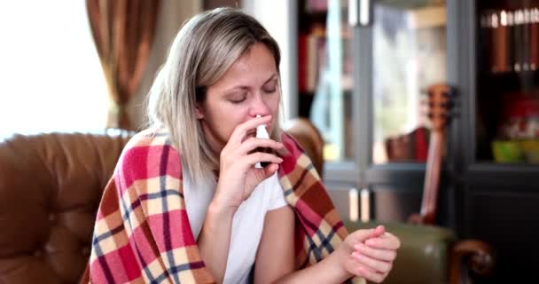 一个坐在沙发上的女人用鼻腔喷雾器 一个特写 慢动作 新月治疗 流鼻涕 — 图库视频影像
