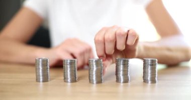 Ahşap masada eşit miktarda gümüş para var, yakın plan. Düzenli katkı payı, kredi faizi, ipotek