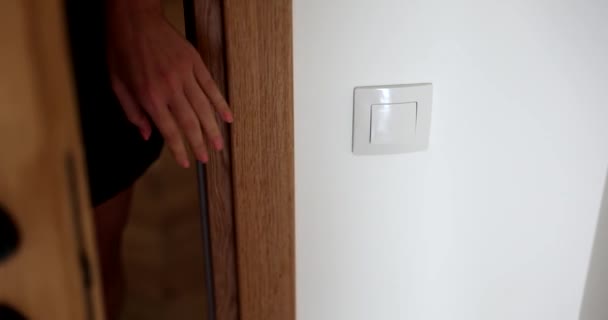 女性はドアを開けて部屋の中の光をオンにし 閉じます アパートの内装の詳細 — ストック動画