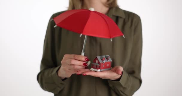赤い傘と家のモデルを持っているリアルエージェントの女性 財産保険のコンセプト ホームと不動産保険のコンセプト — ストック動画
