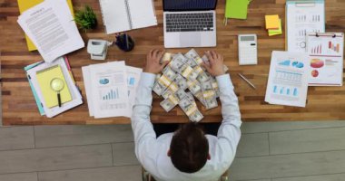Seo işçisinin elinde bir sürü para var. İş adamı işyerindeki ekonomik göstergeleri, raporları ve grafikleri analiz ediyor