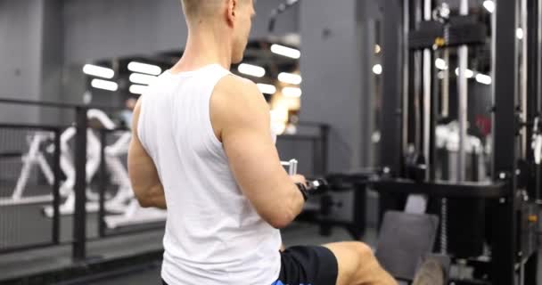 Αρσενικό Bodybuilder Τρένα Άρση Βαρών Στον Προσομοιωτή Στο Γυμναστήριο Αθλητική — Αρχείο Βίντεο