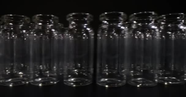 黑暗背景下的空玻璃瓶疫苗 医疗和实验室研究用专业玻璃器皿 — 图库视频影像
