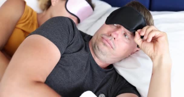Surprised Man Picking His Sleep Mask Looking Woman Lying Him — Stock Video