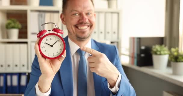 Jovem Homem Negócios Sorrindo Mostrando Tempo Despertador Com Seu Filme — Vídeo de Stock