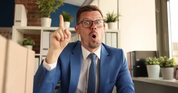 Homem Negócios Surpreso Sentado Mesa Mostrando Dedo Indicador Acima Filme — Vídeo de Stock