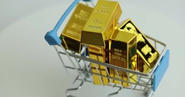 Dönen altın çubuklu metal sepet. Altın ve mali yatırımlar satın almak