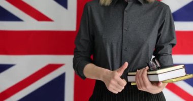 Ders kitapları olan bir kadın İngiliz bayrağını onaylıyor. Londra 'da okuyorum.