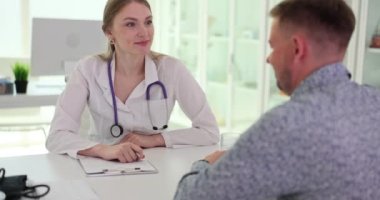 Güzel gülümseyen kadın doktor erkek hastayla iletişim kurar. Sağlık hizmetleri veya sigorta kavramı