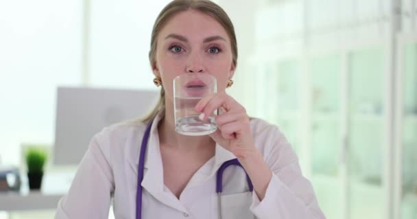 女性医師は清潔な新鮮な水を1杯飲む 健康的な食事やライフスタイルのコンセプト — ストック動画