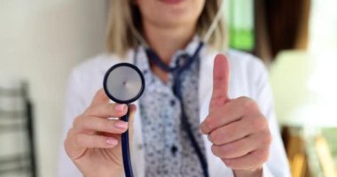Steteskoplu ve baş parmağı havada bir tıp doktoru. Kaliteli tıbbi ve sağlık hizmetleri öneriliyor