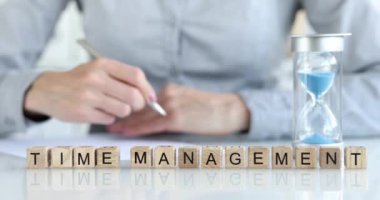 Zaman yönetimi ahşap küplere yakın plan, yüzeysel odaklanma üzerine yazılır. Kadın kalemle yazıyor. Verimli zaman kullanımı