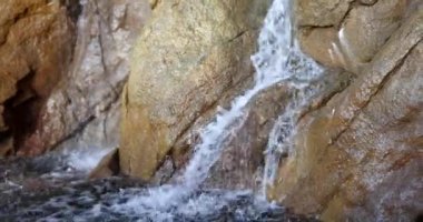 Kayalar ve taşlar arasındaki su akışına yakın. Su kayaların üzerinden akar.