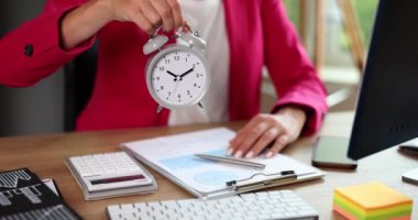Businesswoman holding gray alarm clock in her hands in office closeup 4k movie slow motion. Time management concept