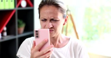 Sad woman with poor eyesight looking at mobile phone screen 4k movie slow motion. Negative news online concept