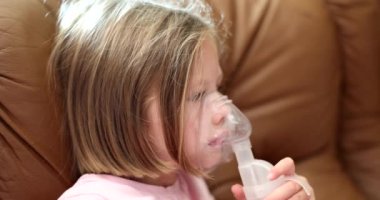 Child making inhalation of hormonal medicine through nebulizer 4k movie slow motion. Treatment of obstructive bronchitis in children concept