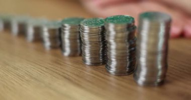 Lot of coins in ascending order standing in front of piggy bank closeup 4k movie slow motion. Cash family savings concept