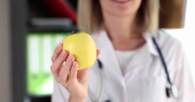 Woman nutritionist holding apple fruit in her hands closeup 4k movie slow motion. Healthy lifestyle proper nutrition concept