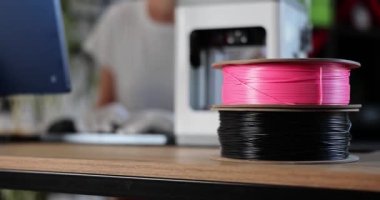 Spools with multicolored plastic for 3D printer on desktop closeup 4k movie slow motion. Materials for 3d design concept