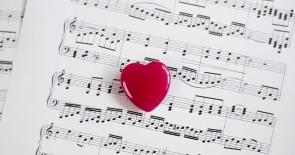 Toy Red Heart Lying Musical Notes Paper Closeup Movie Slow — Video