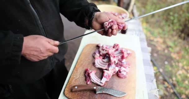 男性料理串に豚カルビのストリングアップ4K映画スローモーション 屋外バーベキューディナーコンセプト — ストック動画