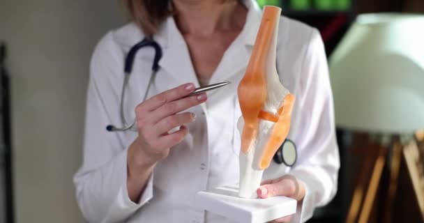 人間のクローズアップ4K映画スローモーションの人工膝関節にペンで示す医師 関節損傷診断と治療の概念 — ストック動画