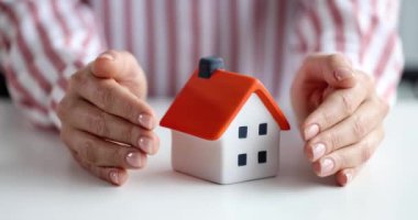 Sigortacı evi elleriyle korur. Ev sigortası konsepti