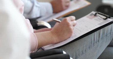 Bir grup insan Amerikan vize başvuru formu dolduruyor. Amerikan Büyükelçiliği konseptine doküman sunmak