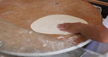 Cook rolls out dough for making pancakes. Cooking traditional turkish tortillas concept