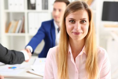 Arka planda güzel bir kadının portresi iş ortaklarının el sıkışması. Birbirinizi selamlamayı kabul edin. El sıkışın.