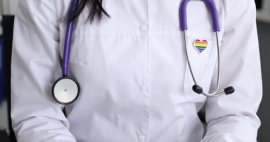 Cebinde steteskop ve LGBT rozeti olan beyaz önlüklü bir doktorun silueti. LGBT toplum kavramından bilim adamları