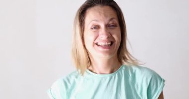 Gülen kadın dans ediyor ve beyaz arka plan 4K filminde baş parmak gösteriyor. Servis kalitesi pozitif ruh hali konsepti