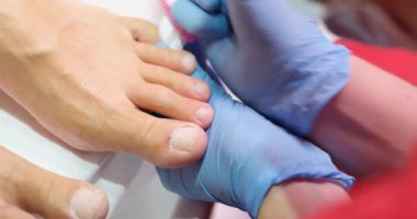 Podiatrist doing pedicure to client using grinding tool closeup 4k movie. Quality professional pedicure concept