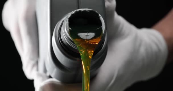 戴橡胶手套的人把汽车机油从塑料瓶中倒入黑色底座 车间汽车发动机用流体润滑剂 汽车服务 — 图库视频影像