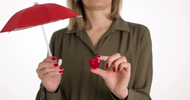 Женщина Покрывает Маленькое Сердце Красным Зонтиком Белой Стене Медицинская Страховка — стоковое видео