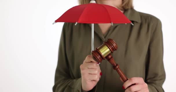Mujer Sostiene Martillo Madera Bajo Paraguas Rojo Contra Pared Blanca — Vídeo de stock