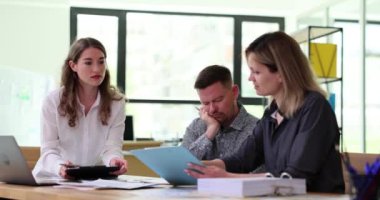 Kadınlar proje belgelerini tartışırken erkek meslektaşım uyuyor. Ofis çalışanları gelişim sürecinin ayrıntılarını ağır çekimde inceler