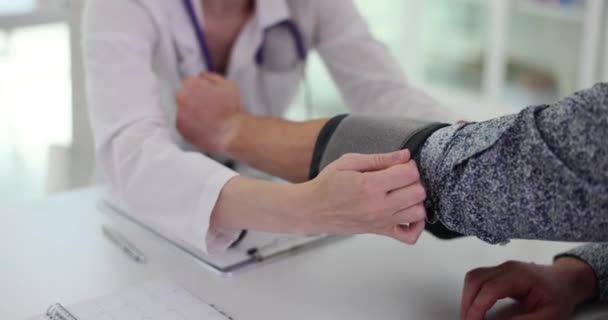 女性看護師は プロの血圧モニターを使用して男性患者の血圧を測定します クリニックオフィスのスローモーションの毎月のチェック — ストック動画
